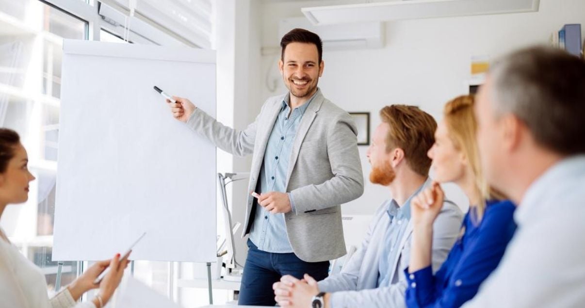 Empleados escuchando a un lider hablando sobre cómo mejorar su marca personal para crecer profesionalmente