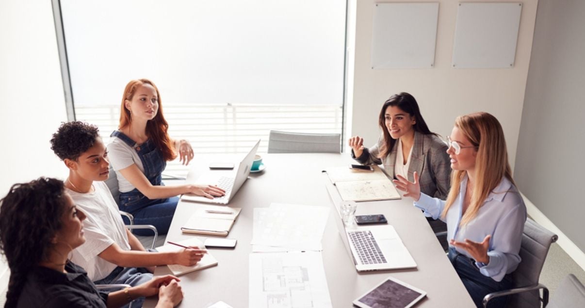 Grupo de mujeres profesionales debatiendo como delegar la toma de decisiones en su empresa