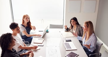 Grupo de mujeres profesionales debatiendo como delegar la toma de decisiones en su empresa