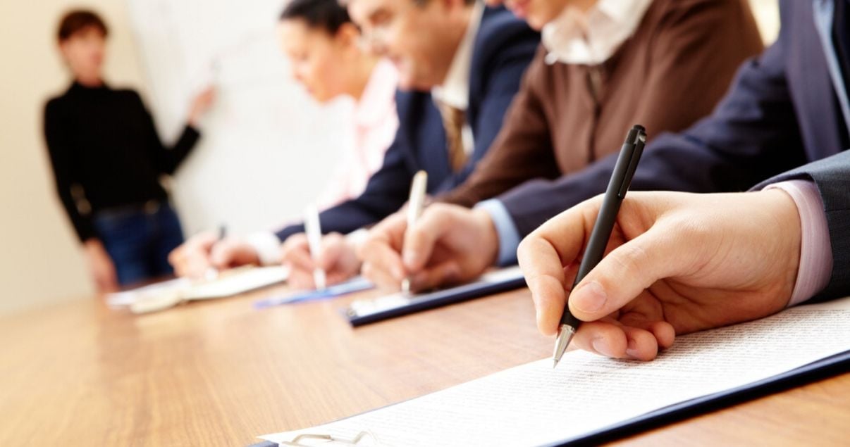 Empleados tomando nota en un curso de capacitación