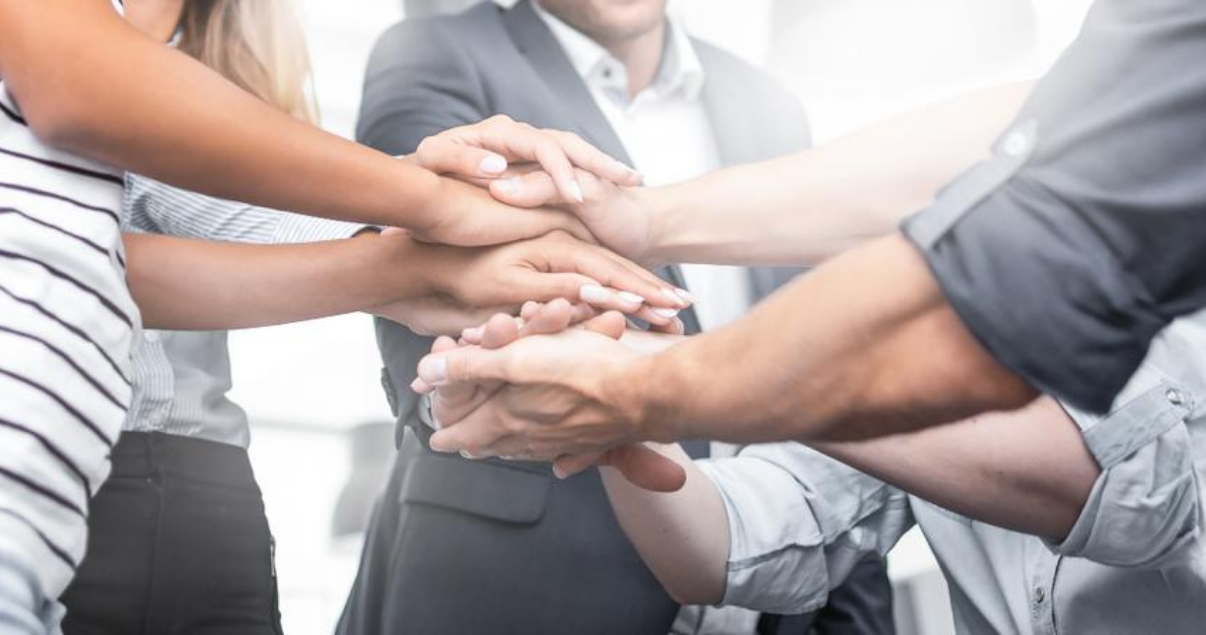 Mano de compañeros de equipo contentos en su espacio de trabajo gracias a la neurociencia aplicada a los recursos humanos y al liderazgo