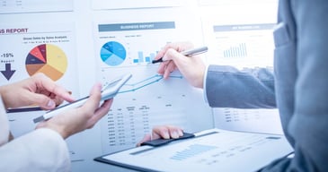 Manos y brazos de profesionales calculando los costos de la gestión de recursos humanos